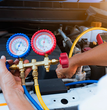 auto mechanic works to repair air conditioning
